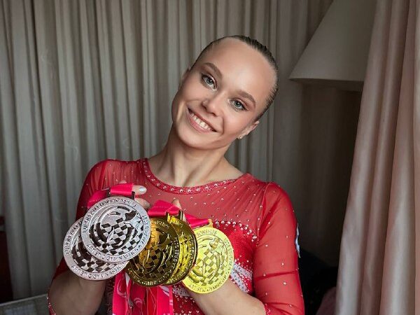Ангелина Мельникова в красном гимнастическом купальнике с медалями