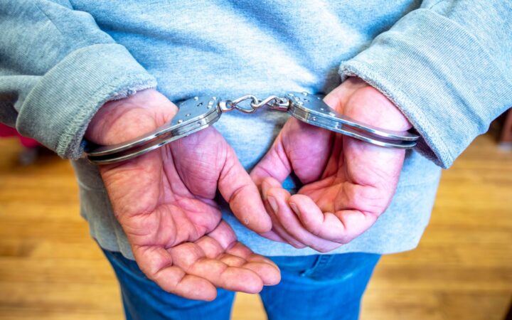 Крупный план лицом к наручникам, одетому в серый свитер, в помещении в Польше.