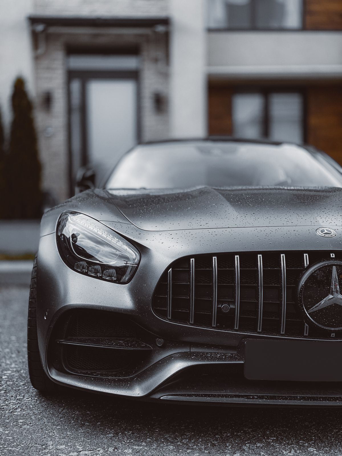Близкий план элегантного автомобиля Mercedes Benz, демонстрирующего роскошный дизайн на фоне города.